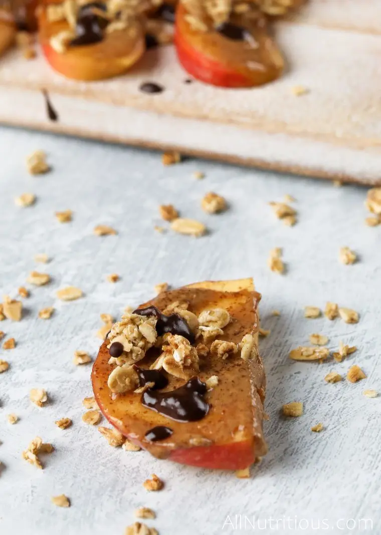 single apple slice with almond butter and toppings
