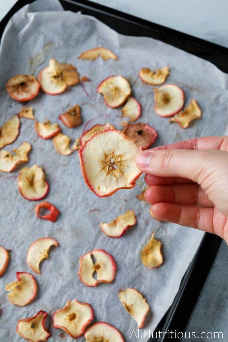 holding apple chip over sheet pan