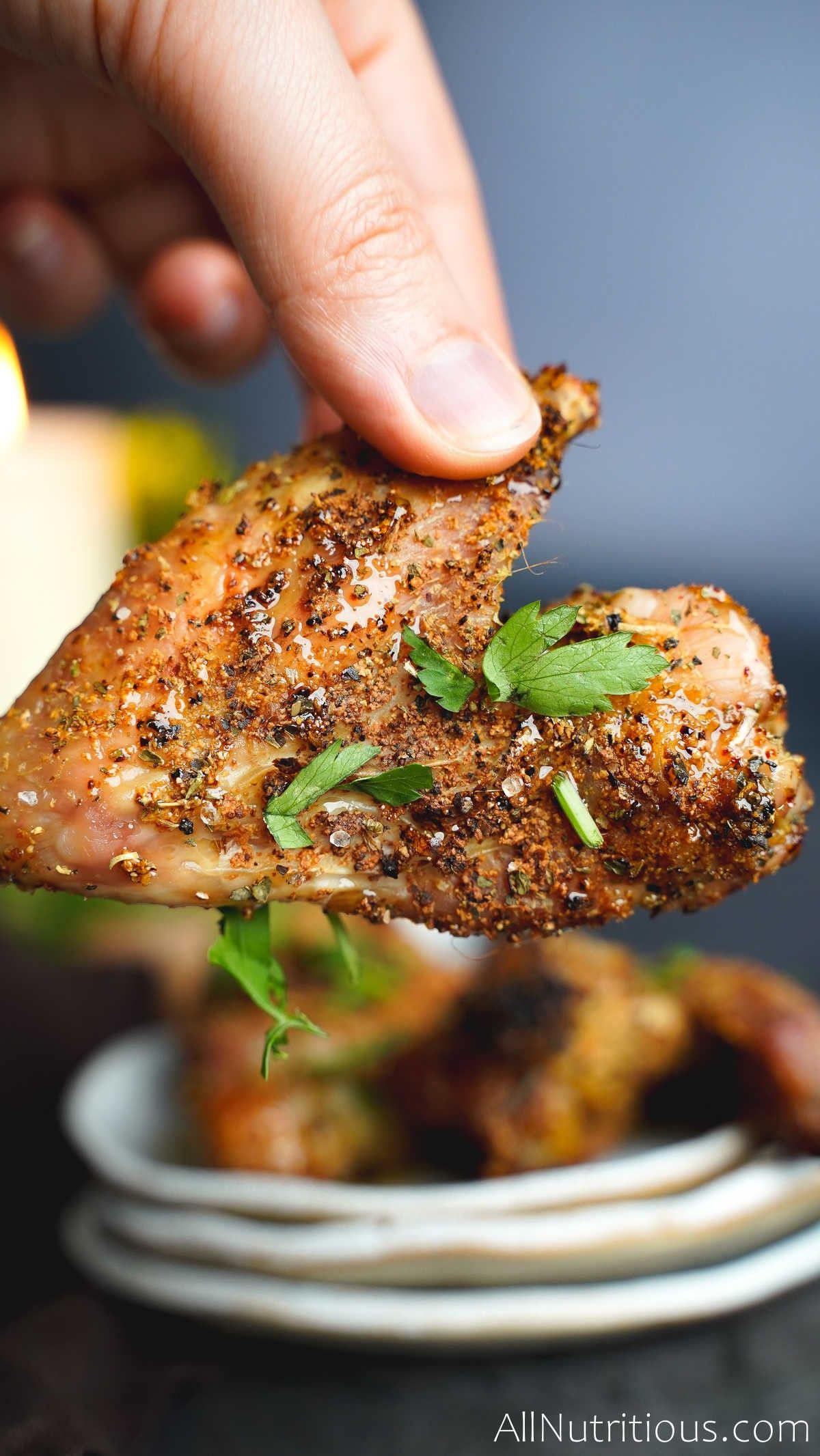 holding honey chicken wing up close