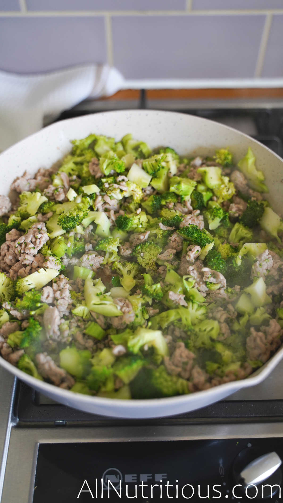 pork and broccoli cooking in pan